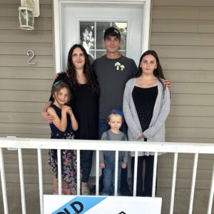 Habitat Family from Hanover stands in front of their door